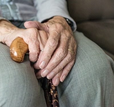 Elderly person holding a walking stick