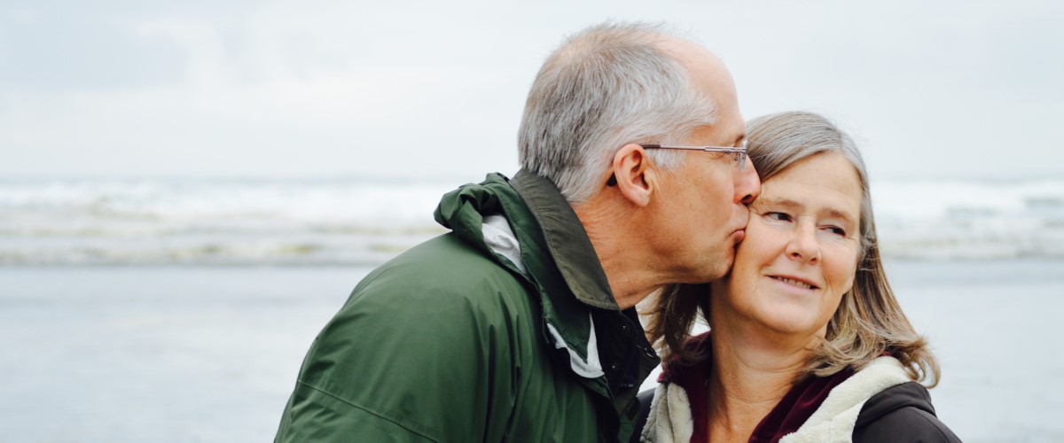 Old man kisses old woman on the cheek