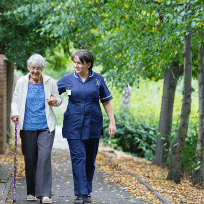 Older Woman walking with domiciliary care worker