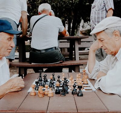 elderly people playing chess