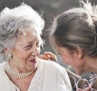 an elderly lady smiling at her carer